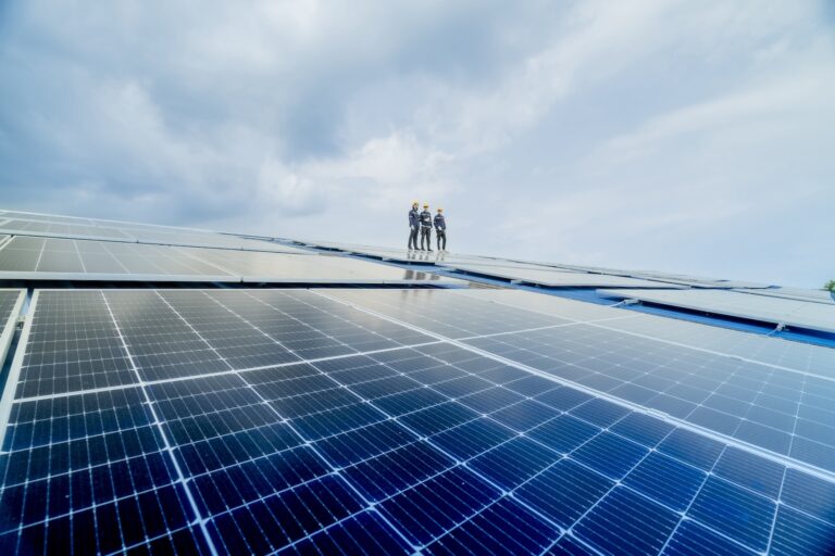 engineer man inspects construction of solar cell panel or photovoltaic cell by electronic device. Industrial Renewable energy of green power. factory worker working on tower roof